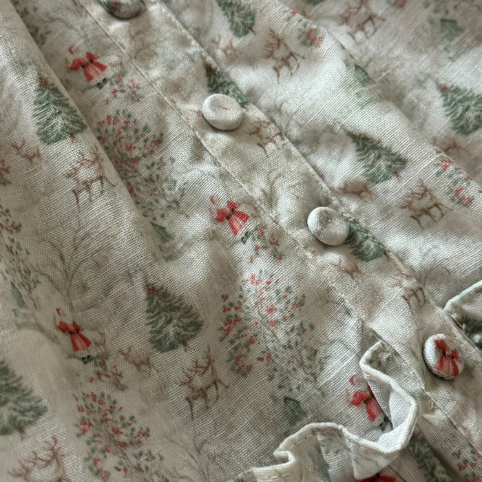 Close-up of Christmas nap dress fabric with white button detailing