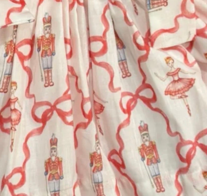Ivory Christmas fabric with red ribbon bows and nutcracker illustrations