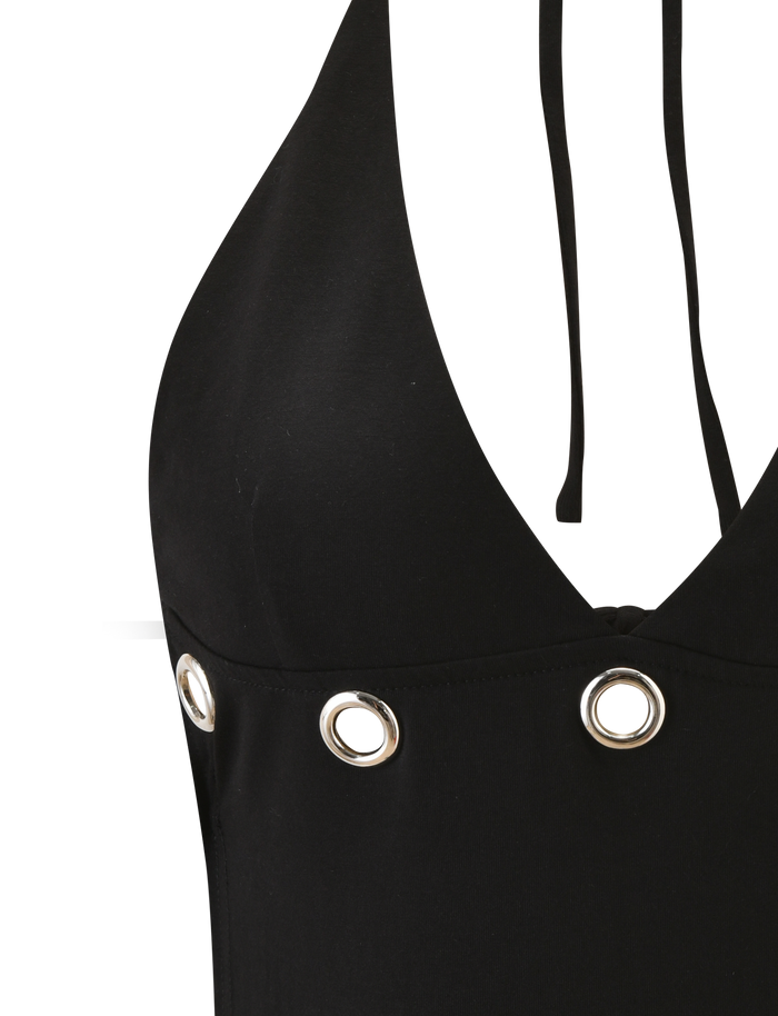 Close-up of the TIGERMIST MARREN TOP - BLACK, a chic backless halter neck top featuring silver eyelets along the chest and two thin black straps, displayed against a white background.