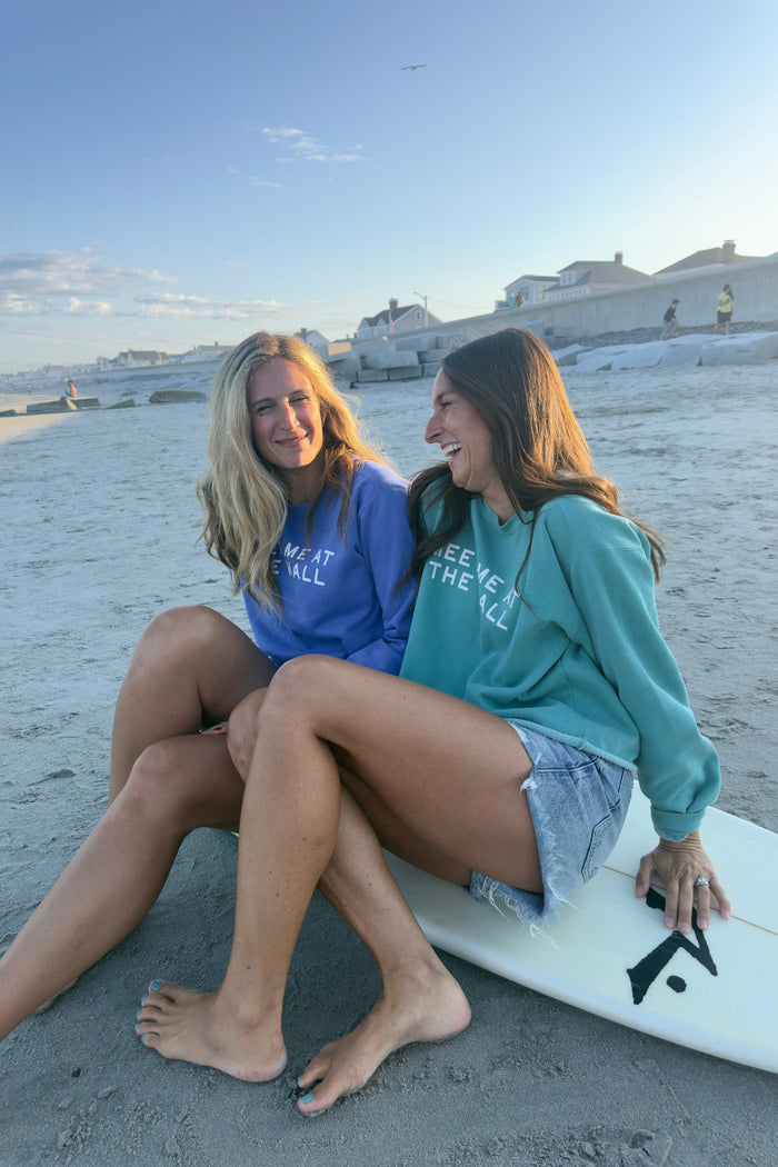 Friends wearing Meet Me At The Wall sweatshirts on the beach