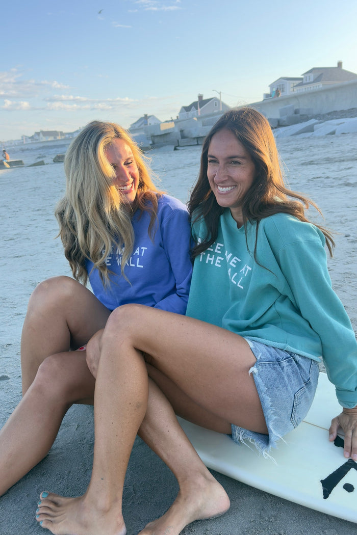 Meet Me At The Wall seafoam sweatshirt on model laughing with friend at the beach