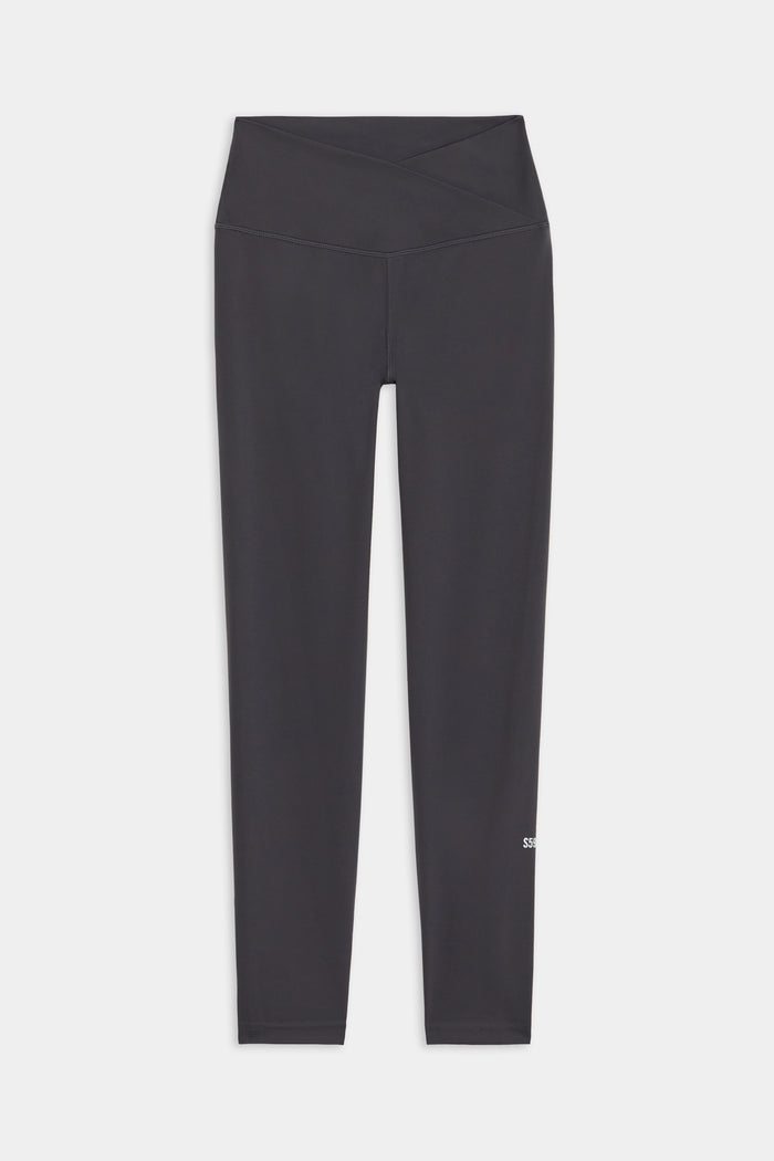 The SPLITS59 Mia Rigor 7/8 leggings in Graphite feature a high-waisted, crossover waistband and are crafted from durable Rigor fabric for essential performance, shown flat against a white background.