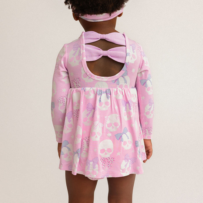 Back view of a child wearing the Posh Peanut Ms. Kelly Bow Back Bodysuit Dress, showing the back cutout with bow details, white background