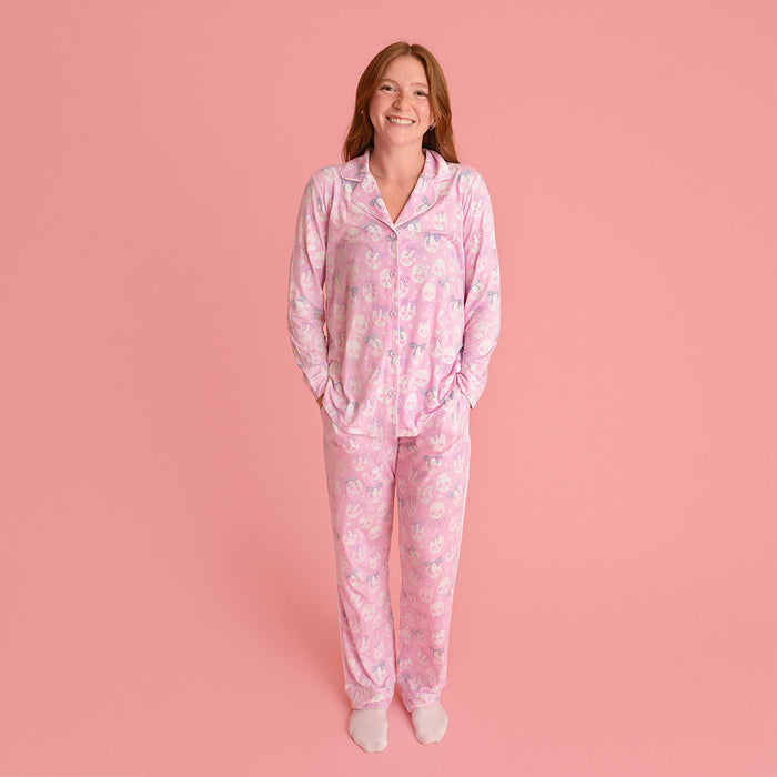 Woman standing, wearing the Posh Peanut Ms. Kelly Women's Luxe Pajama Pant Set, coral background