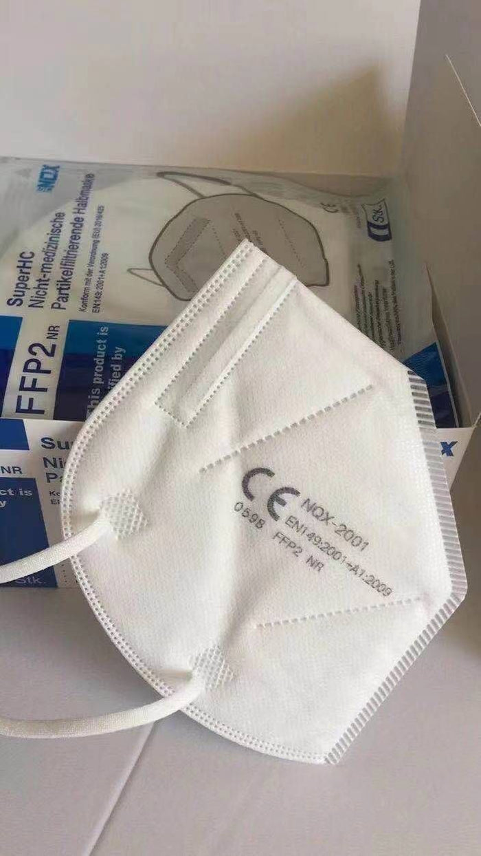 NQX white KN95 face mask next to its packaging