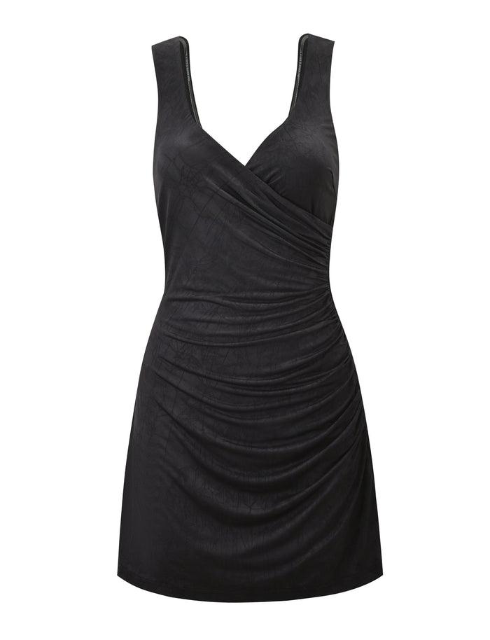 The NURA MINI DRESS - BLACK by TIGERMIST is a sleeveless, fitted mini dress featuring a V-neckline, side ruching, smooth shiny fabric, and a chic open back for added allure.