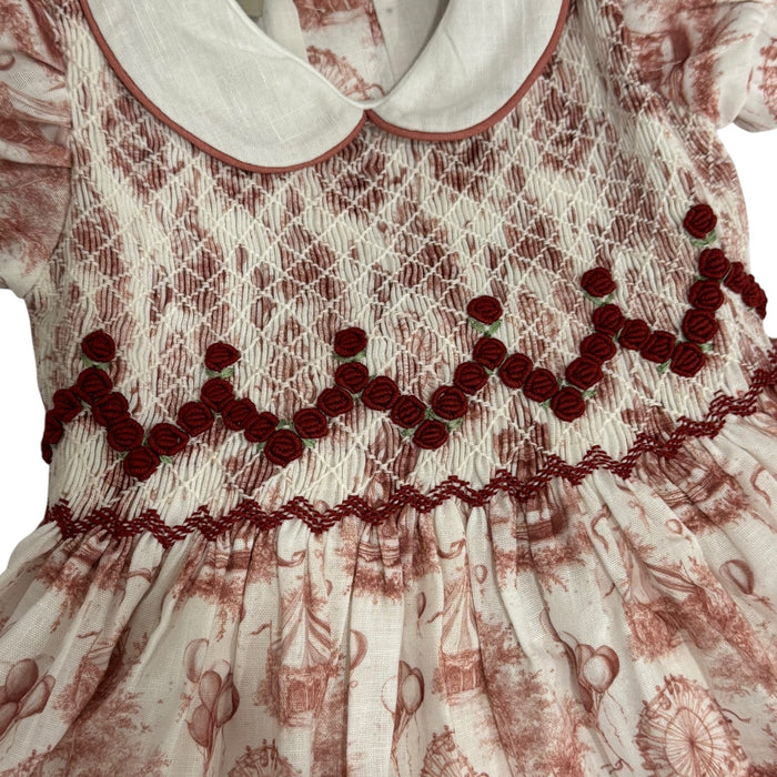 Close-up of burgundy handsmocking and rounded ivory collar on Ollie Circus Carousel Dress