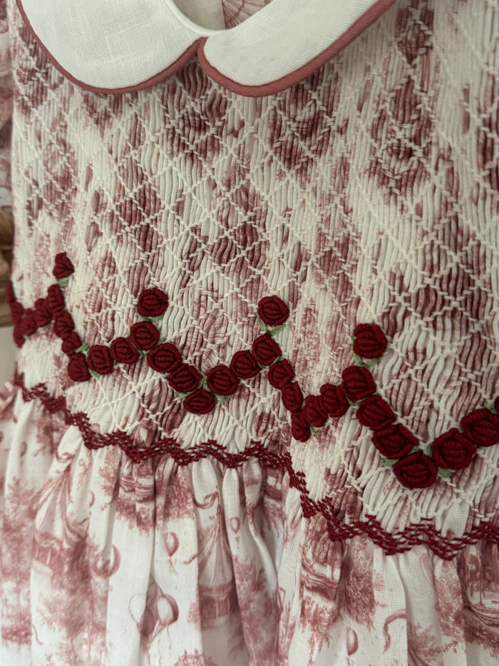 Close-up of intricate burgundy handsmocking on Ollie Circus Carousel Girl Dress