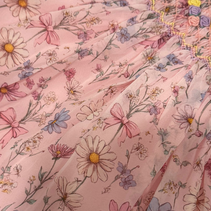 Close-up of pink organza fabric with delicate floral and bow print