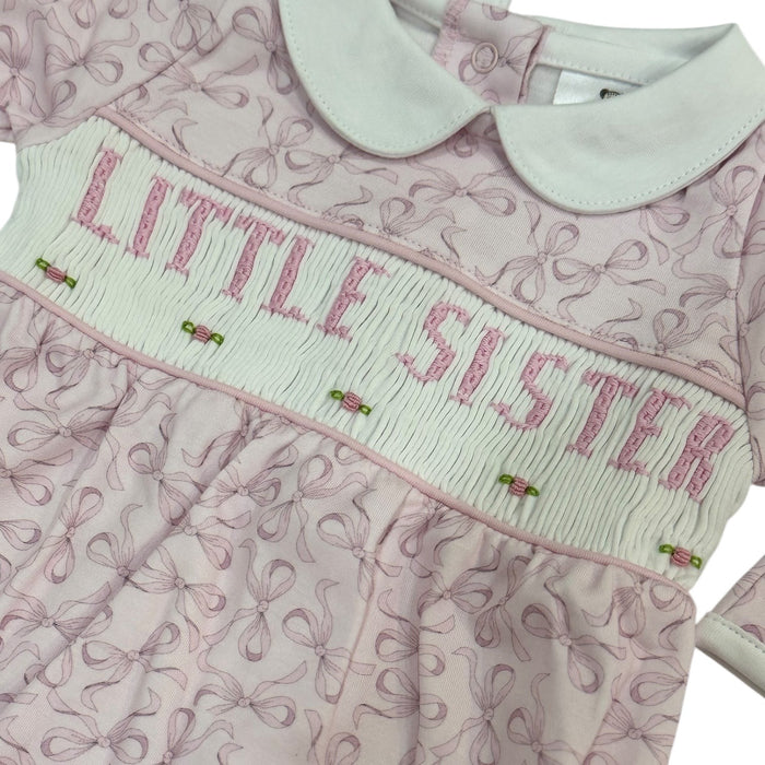 Close-up of handsmocked “LITTLE SISTER” lettering and pink bow print