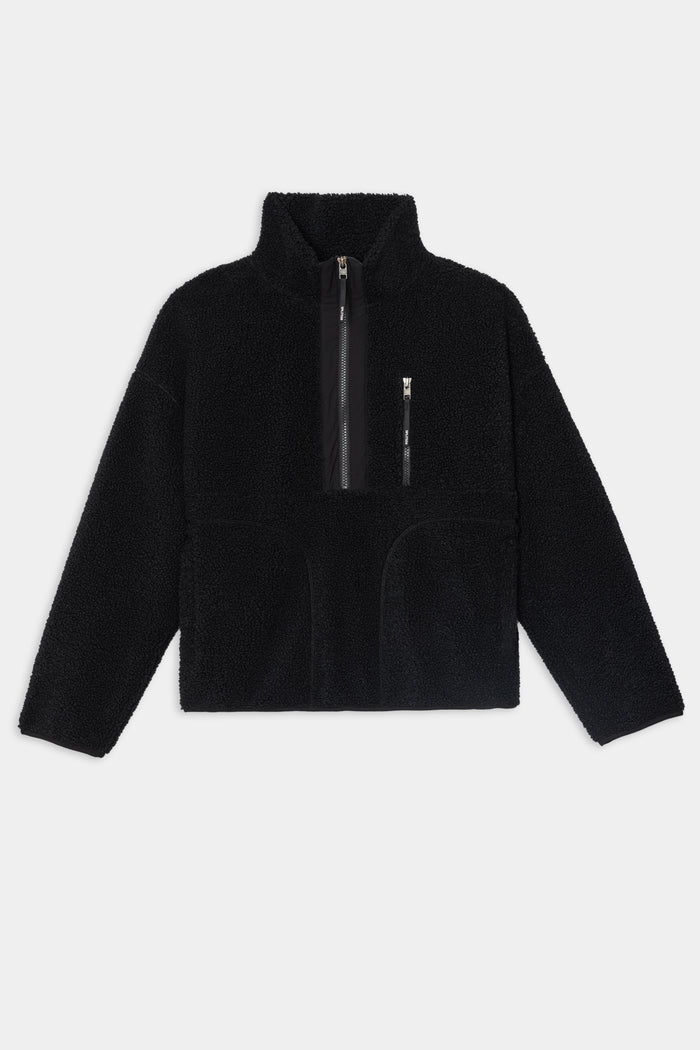 The SPLITS59 Reese Sherpa Half Zip Pullover in black, crafted from soft 100% polyester, features a high collar, half-zip front, zippered chest pocket, and two front hand pockets, shown laid flat on a white background.