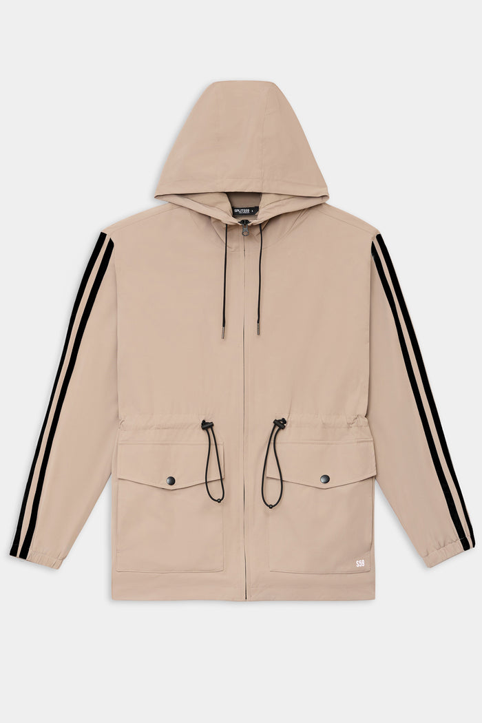 The SPLITS59 Reggie Water Repellent Jacket in Latte/Black features a lightweight design, black drawstrings, two front flap pockets, and black sleeve stripes—a versatile choice for any occasion.