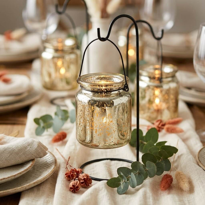 Gold mercury glass hanging holders on a decorated tablescape with eucalyptus and linen linens