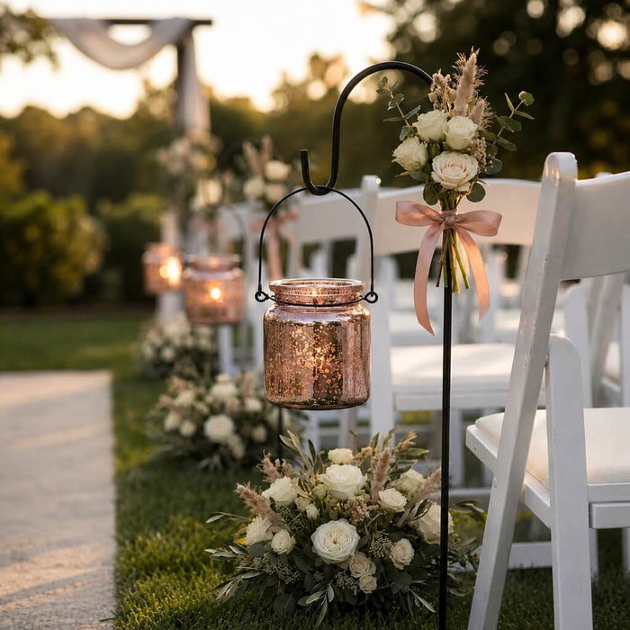 Rose gold hanging candle holder with white floral decor beside outdoor wedding chairs