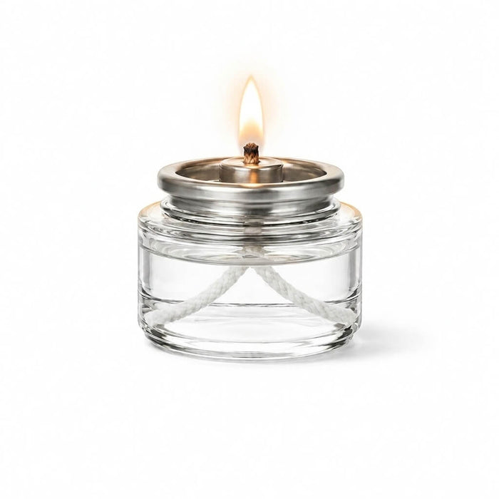 Lit Liquid Paraffin Fuel Cell in clear glass container with silver top and white wick