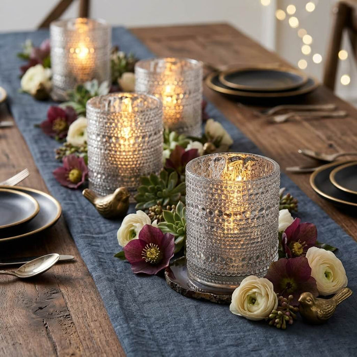 Pearly silver candle holders with floral decor on a rustic wooden dining table