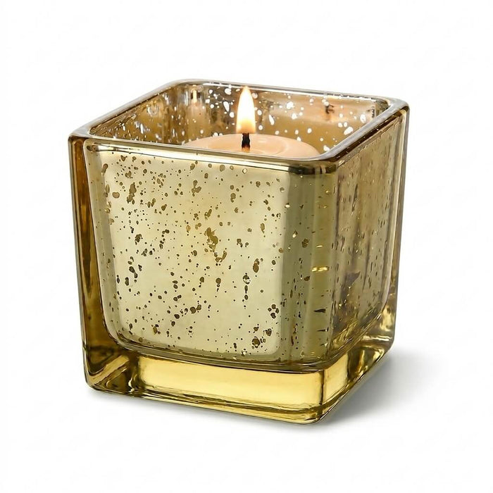 Metallic gold mercury square votive holder with lit candle on white background