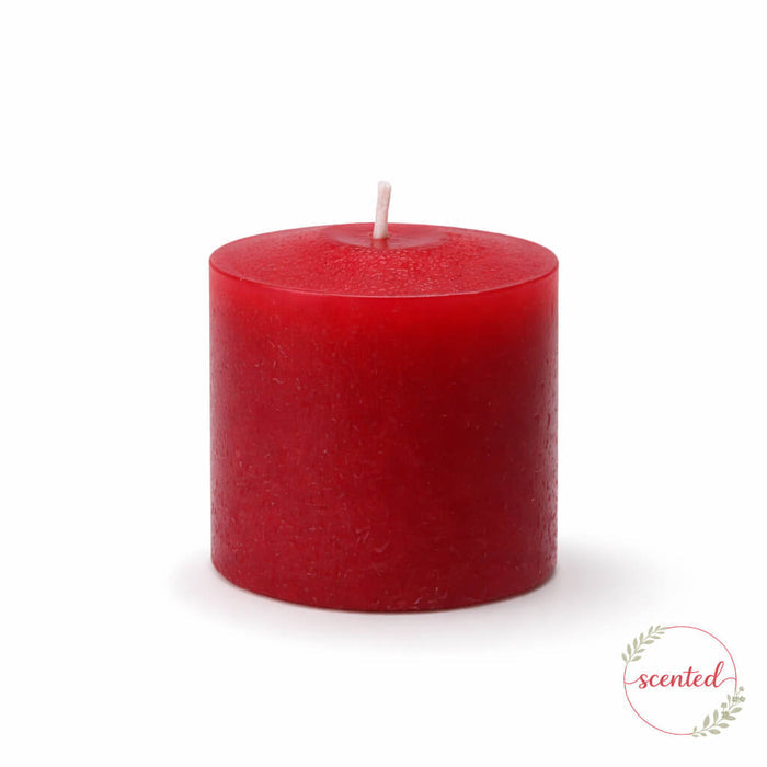 Apple Cinnamon scented red pillar candle on a white background