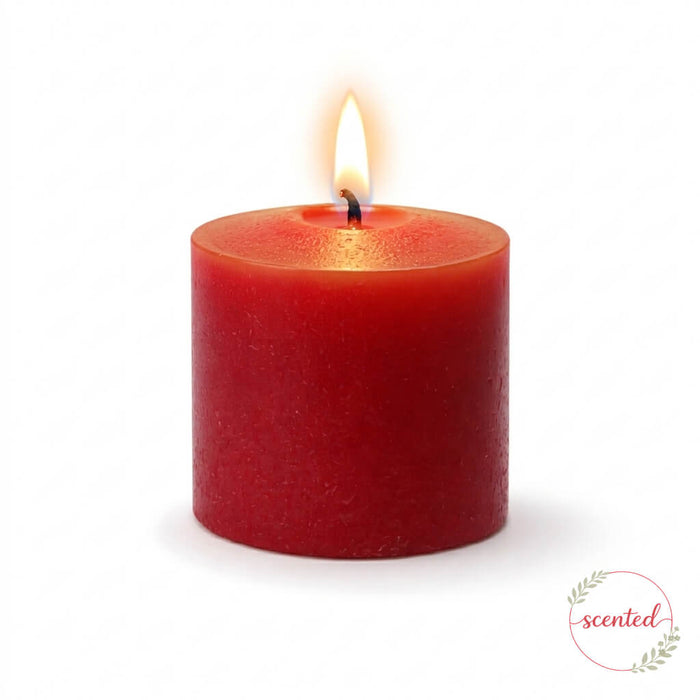 Apple Cinnamon scented red pillar candle with a lit flame on a white background