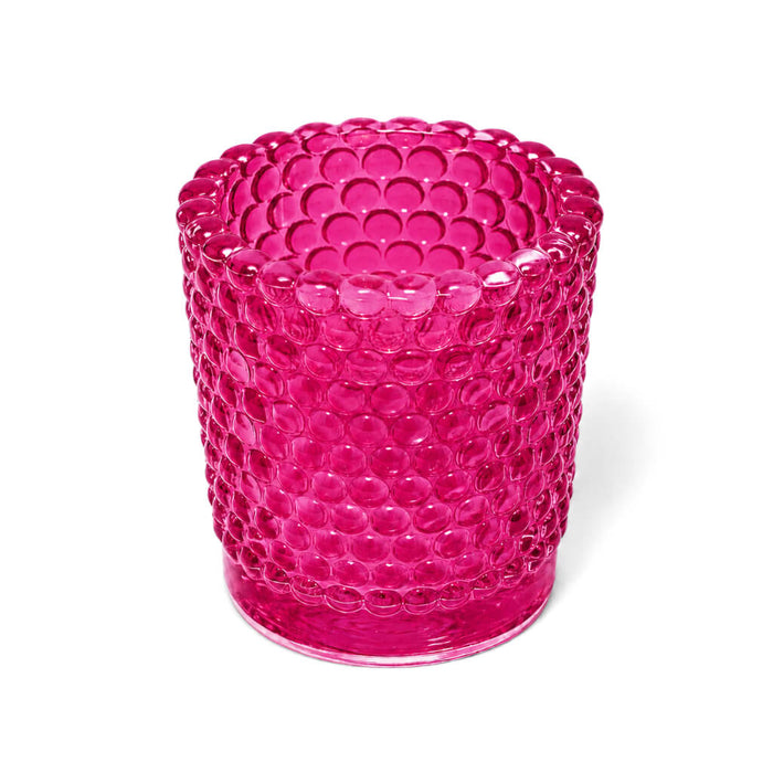 Pink hobnail glass votive holder on white background