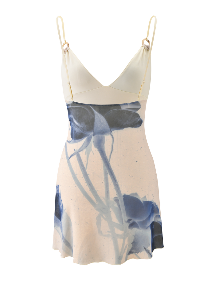 The TIGERMIST ROSY MINI DRESS - INDIGO FLORAL is a sleeveless cream mini dress with adjustable cami straps, a V-neckline, and a bold blue abstract rose print for a fresh, modern style.