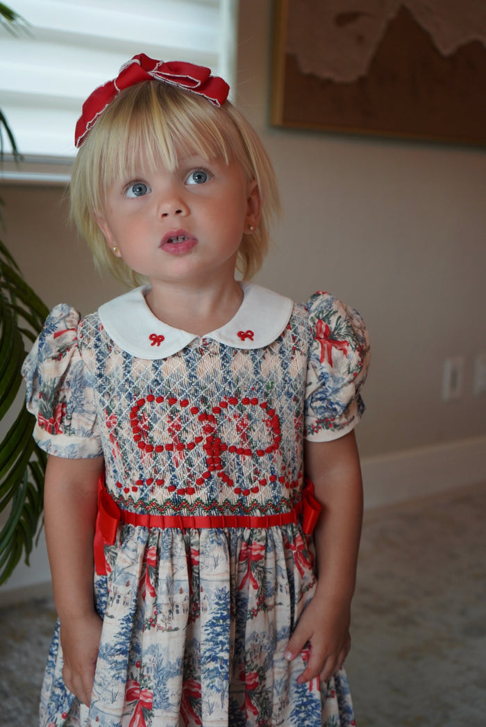 Girl wearing The Polar Express Bow Girl Handsmocked Dress
