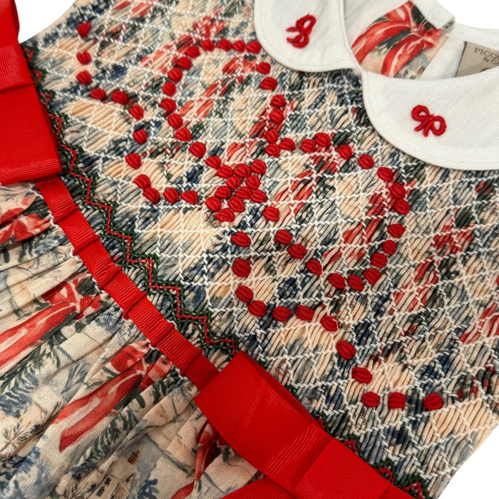 Close-up of red ribbon waist detail and train toile print on The Polar Express dress