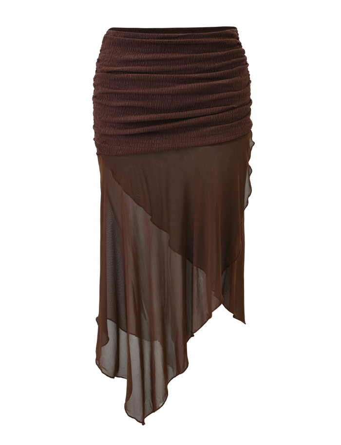 The TIGERMIST ZINNIA MIDI SKIRT in chocolate features a textured stretch knit waistband and a sheer, asymmetrical hem for a stylish, layered, flowy look.